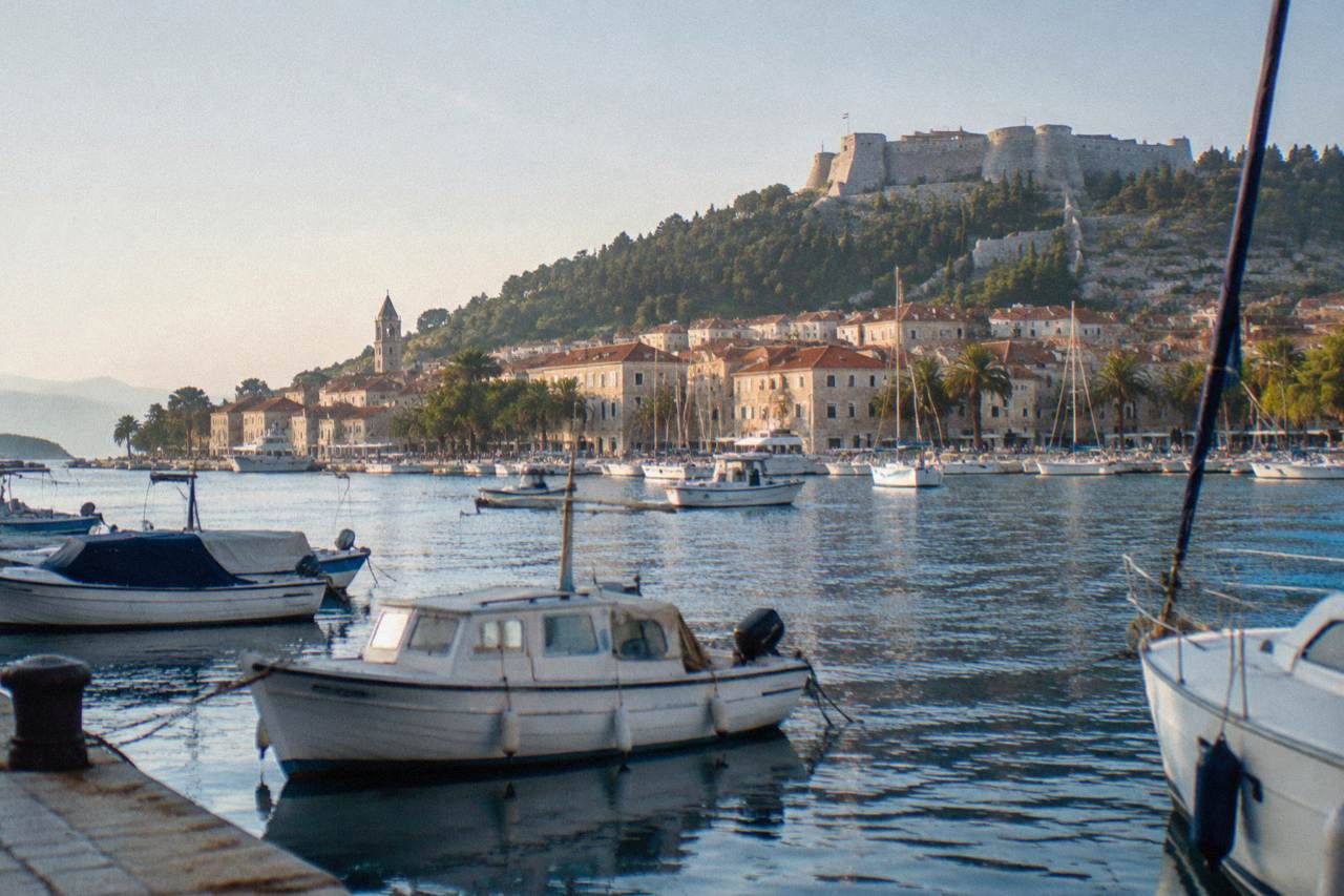 Boats moored in Hvar town harbour with the fortress hill above the rooftops