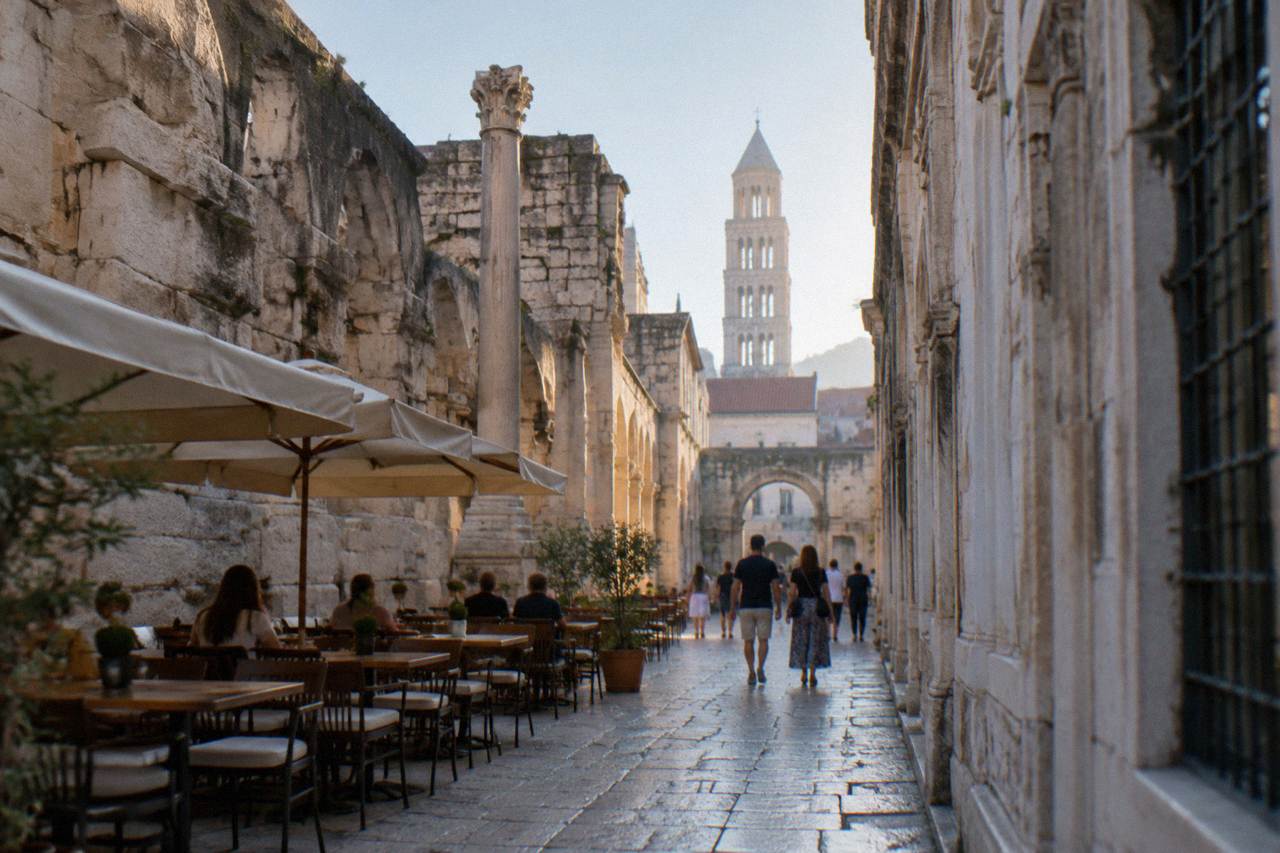 Pedestrian stone street inside Diocletian's Palace in Split with cafe tables and people walking