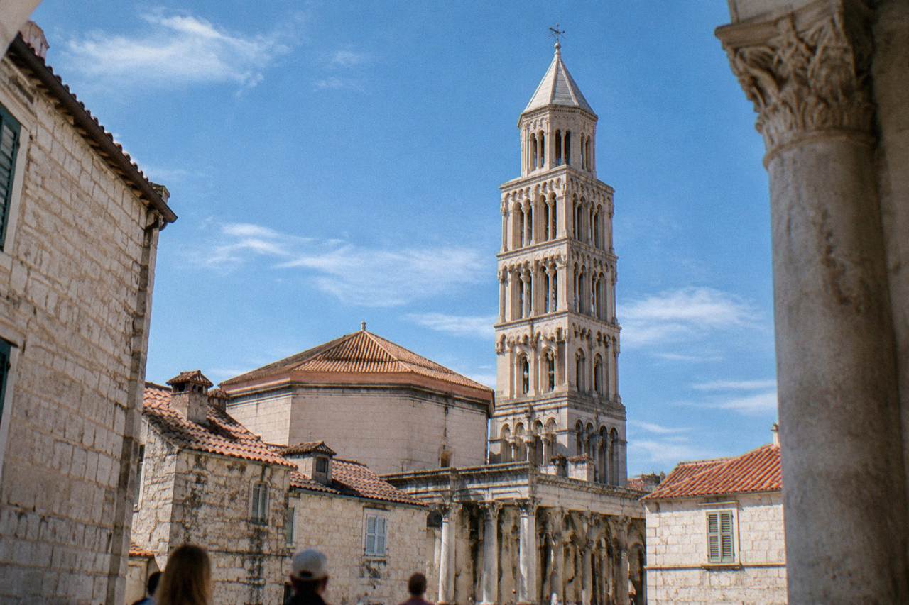 The stone facade and bell tower of the cathedral rising above the rooftops inside Diocletian's Palace in Split