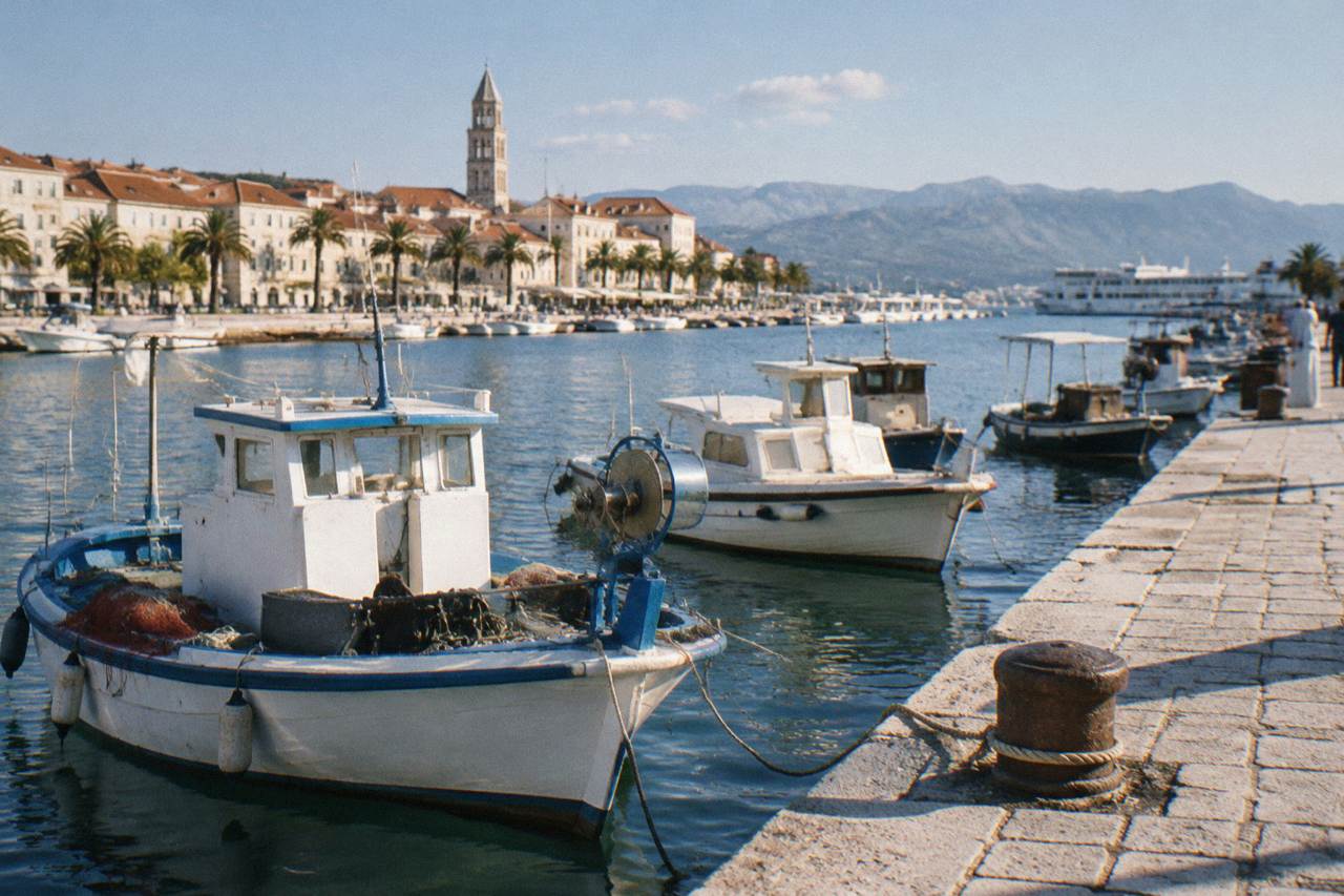 Fishing boats and stone quayside in a Dalmatian coastal town at midday