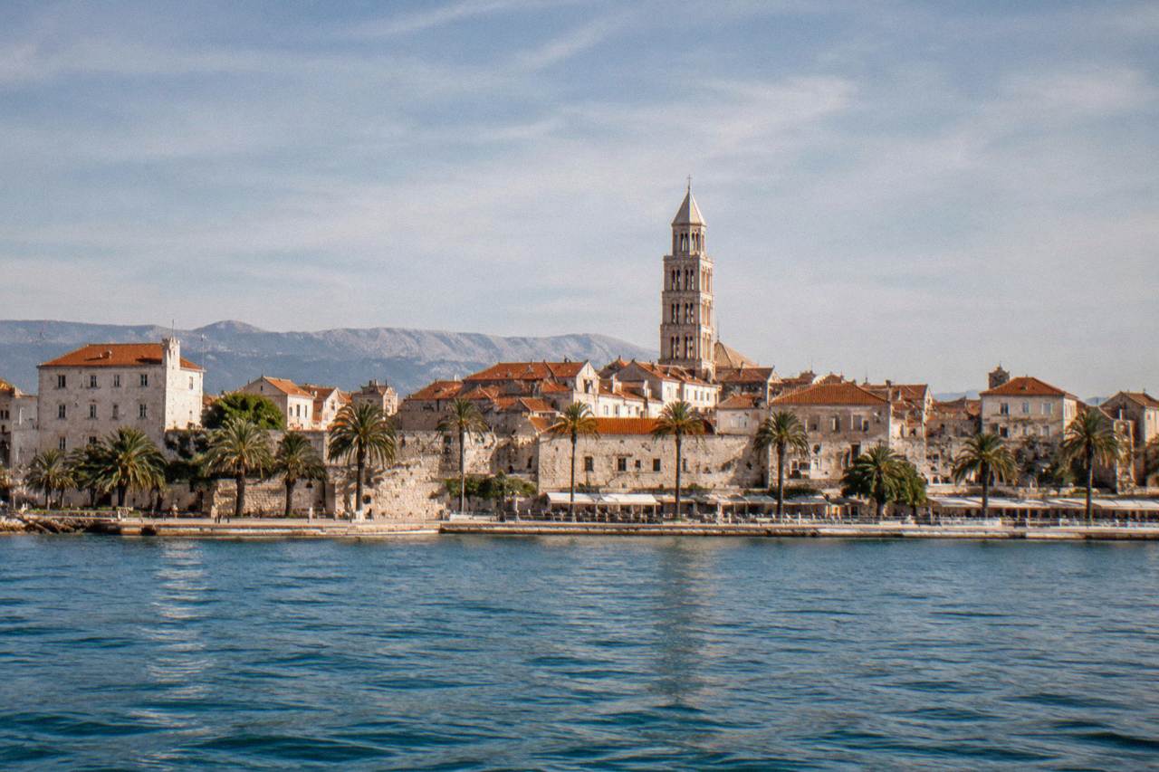 The stone walls and red roofs of Split old town seen from the sea on a clear day