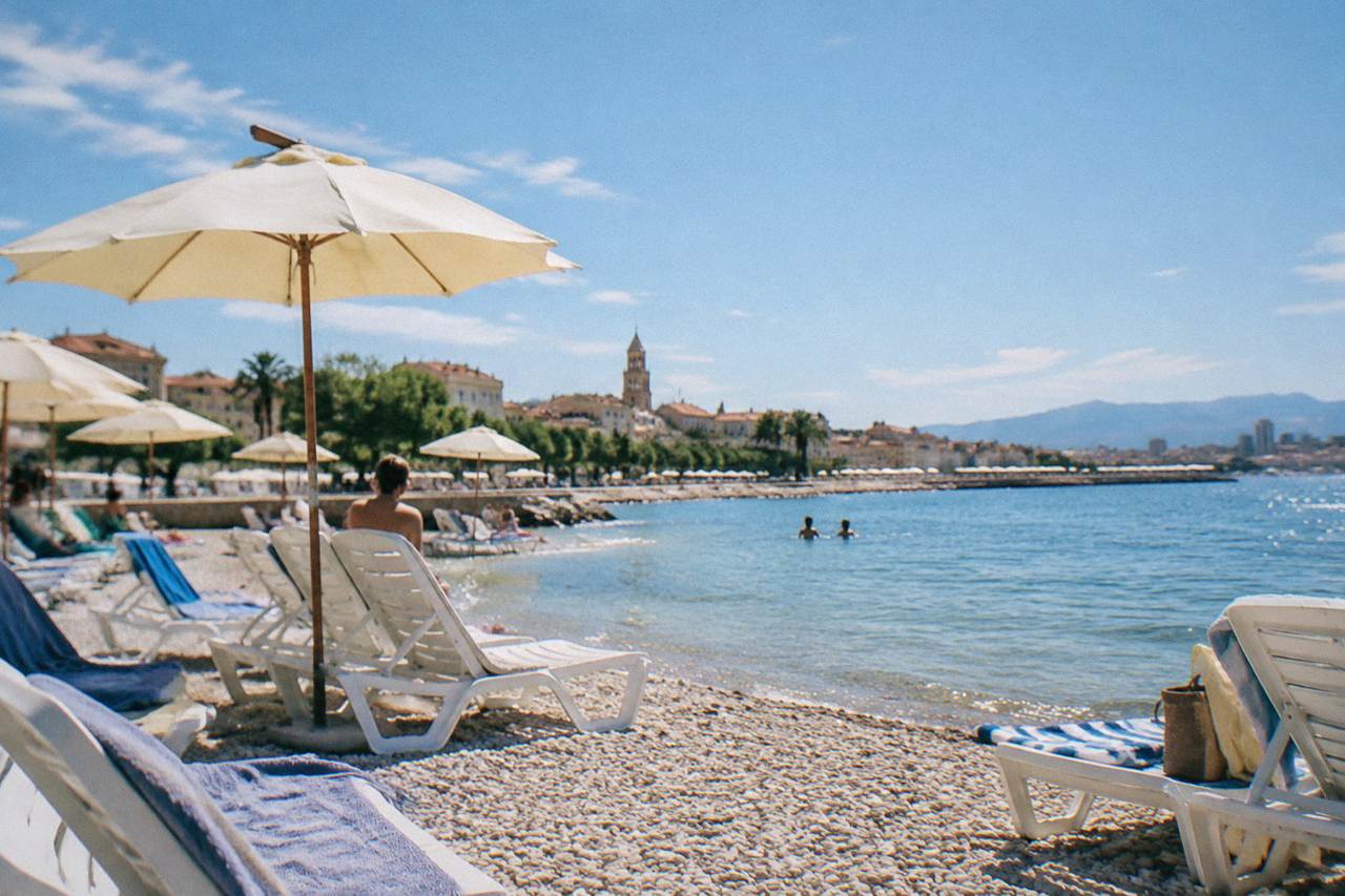 Sun loungers and parasols on a pebble beach beside the Adriatic sea in Split