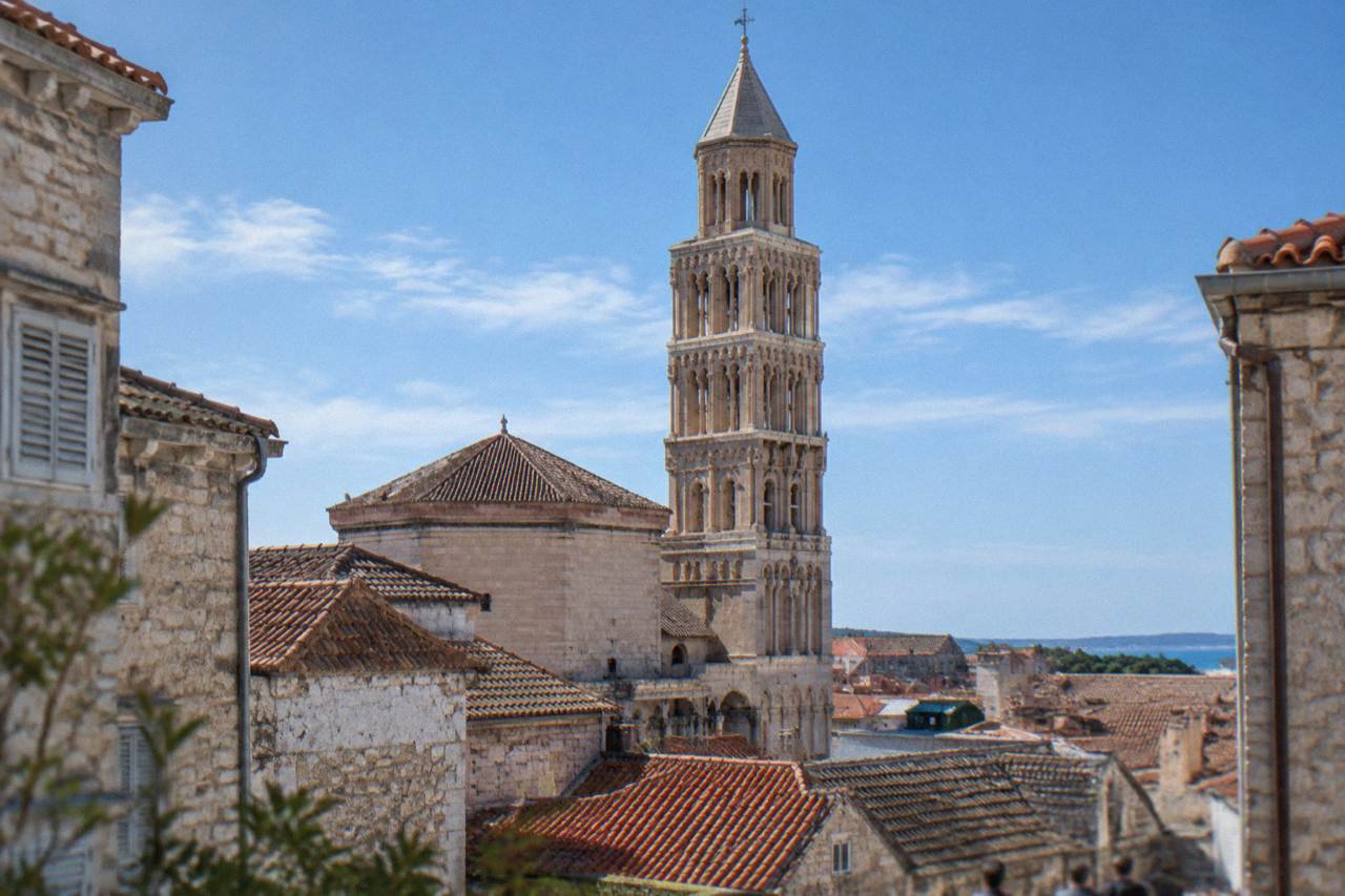 The stone facade and bell tower of the Cathedral of St Domnius rising above the rooftops inside Diocletian's Palace in Split