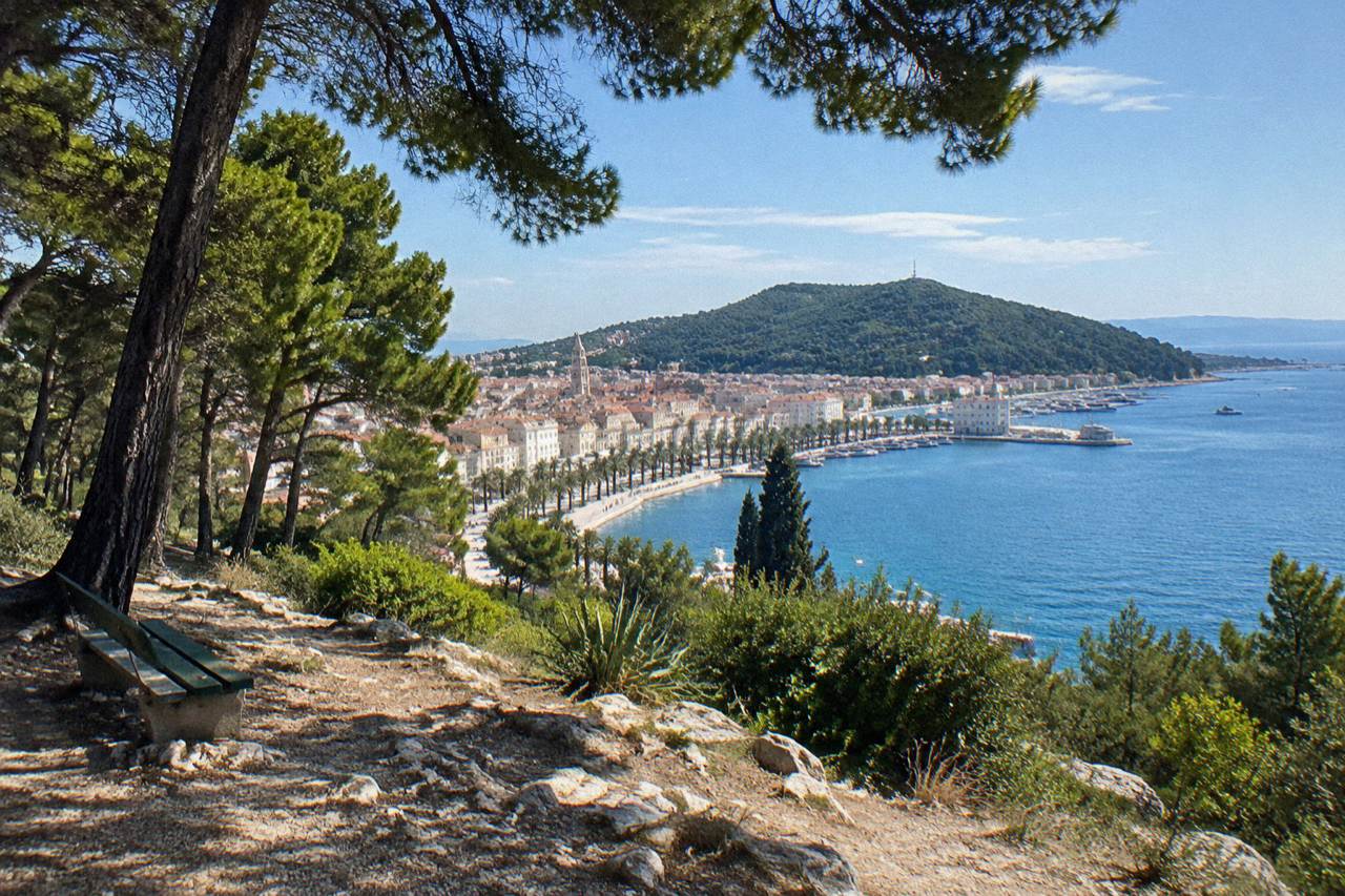 The Adriatic seafront of Split with the Marjan peninsula and palm trees along the Riva