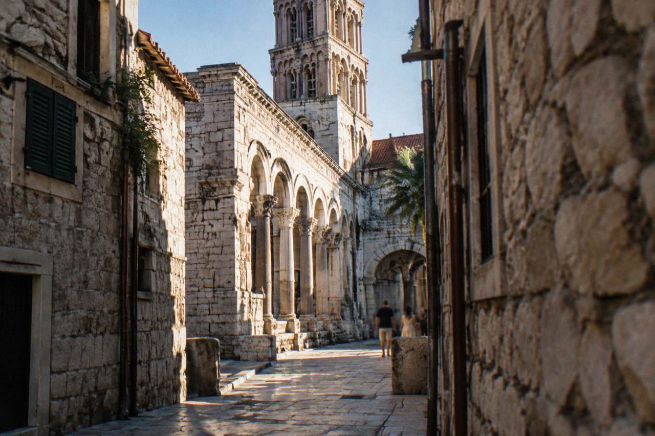 Stone walls and arches of Diocletian's Palace in Split seen from a narrow old town lane
