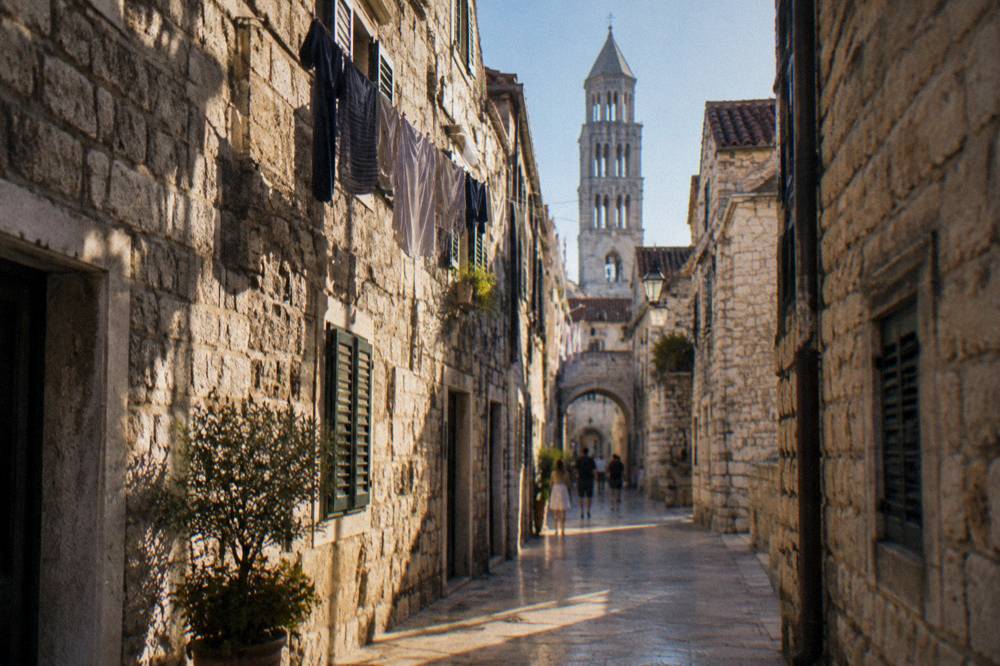 Polished limestone alley in the Split Old Town with stone buildings and hanging laundry