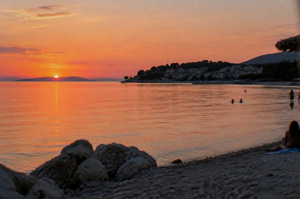 An evening sky over the calm bay and peninsula of Stobrec