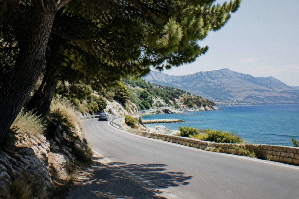 Coastal road east of Žnjan curving toward the Omis hills south of Split