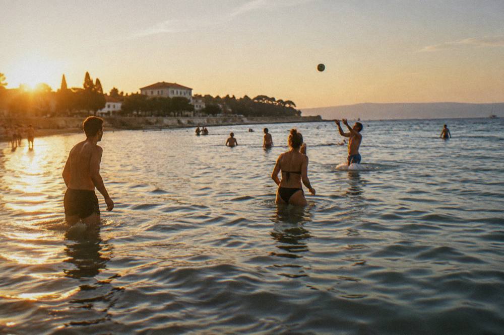Players standing in shallow water hitting a small ball above the surface