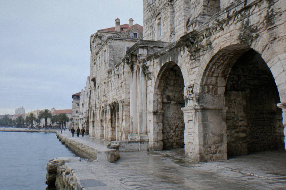 Early morning light on the stone facade of the palace above the seafront