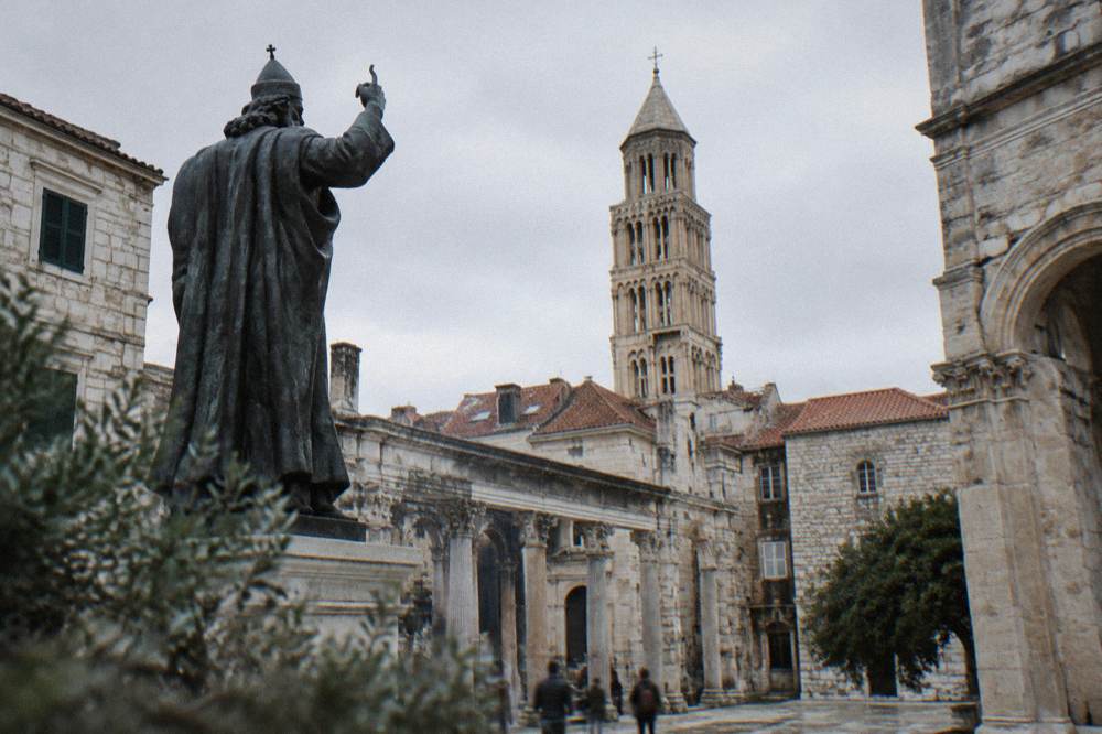 The central courtyard of Diocletian's Palace with Roman columns and the cathedral bell tower rising above the rooftops