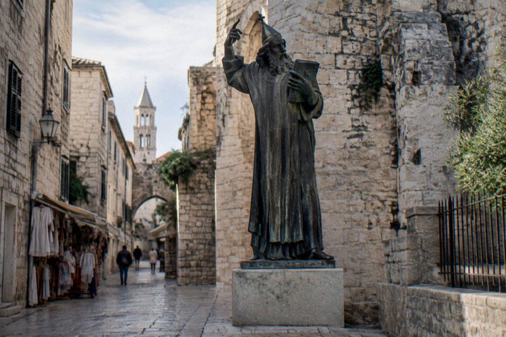 A narrow stone street inside Diocletian's Palace lined with small shops and stone walls