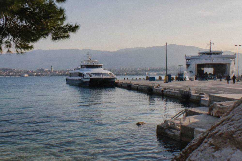 A ferry port with a catamaran and a car ferry at the quays in late afternoon light