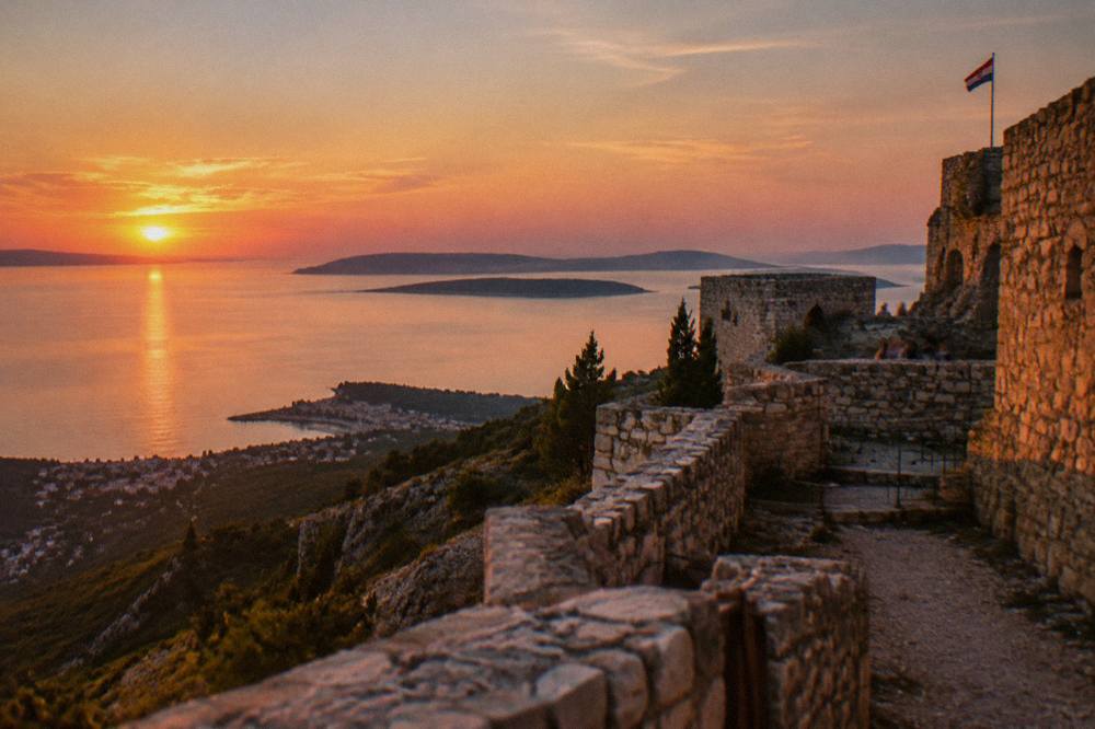Sunset light on fortress walls with the sea and distant islands in the background