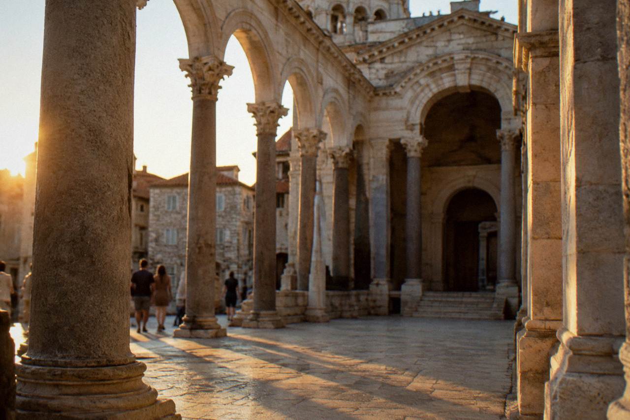 A colonnaded stone square inside Diocletian's Palace with cathedral arches rising behind the columns