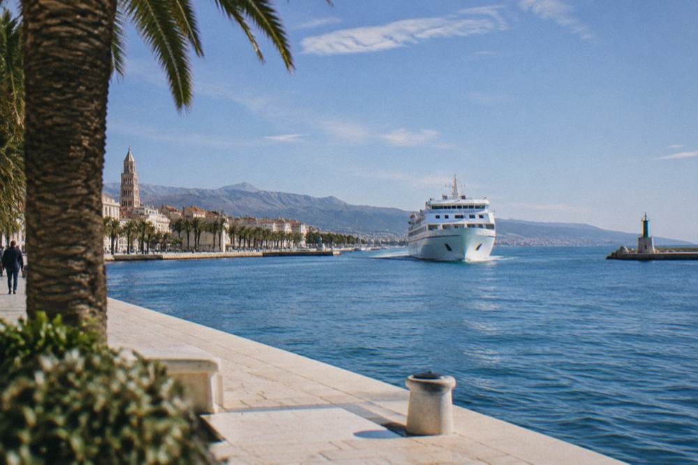 White passenger ferry approaching the Split harbour piers seen from the promenade