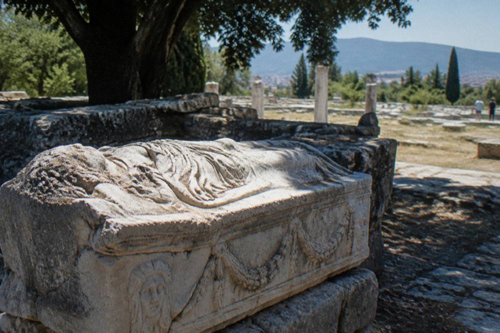 Close view of a carved Roman sarcophagus lid resting on stone at Salona