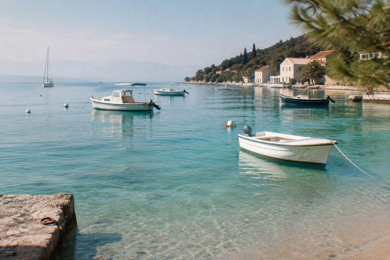 A calm turquoise lagoon with small boats anchored over sandy shallows
