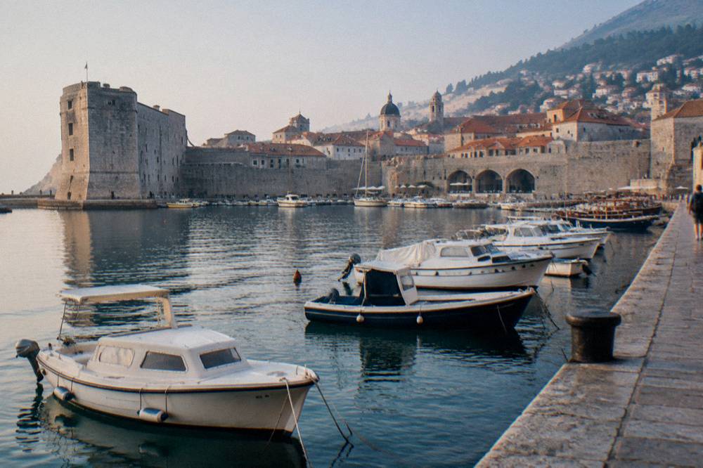 Dubrovnik old harbour with small boats moored against stone quays
