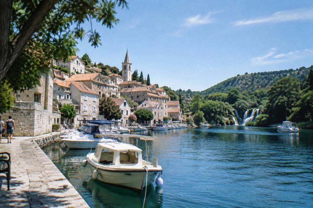 Small stone town beside a river with moored boats