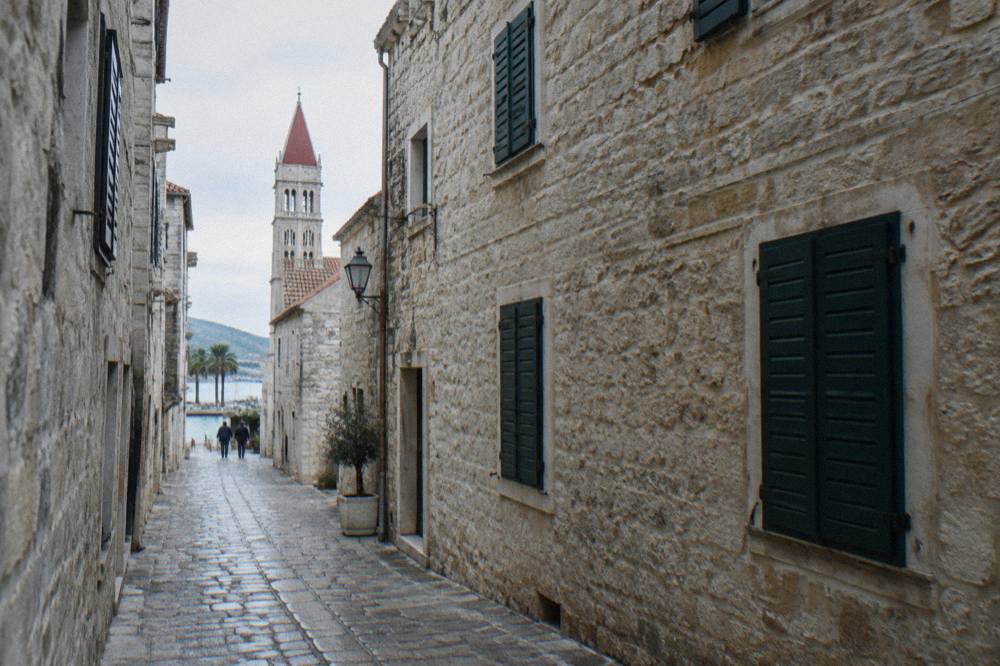 Narrow stone street in an old Dalmatian town with shuttered facades