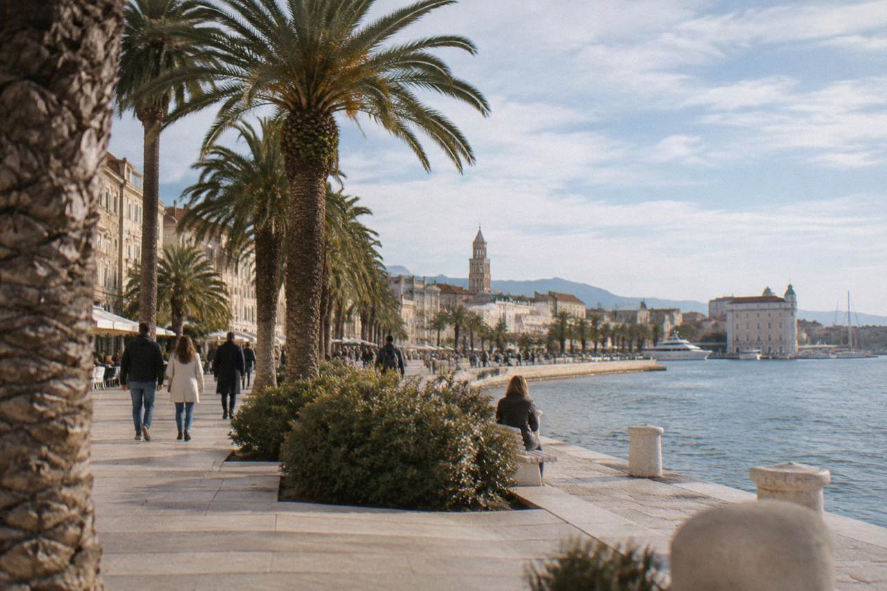 The Riva waterfront promenade in Split lined with palm trees beside the Adriatic Sea