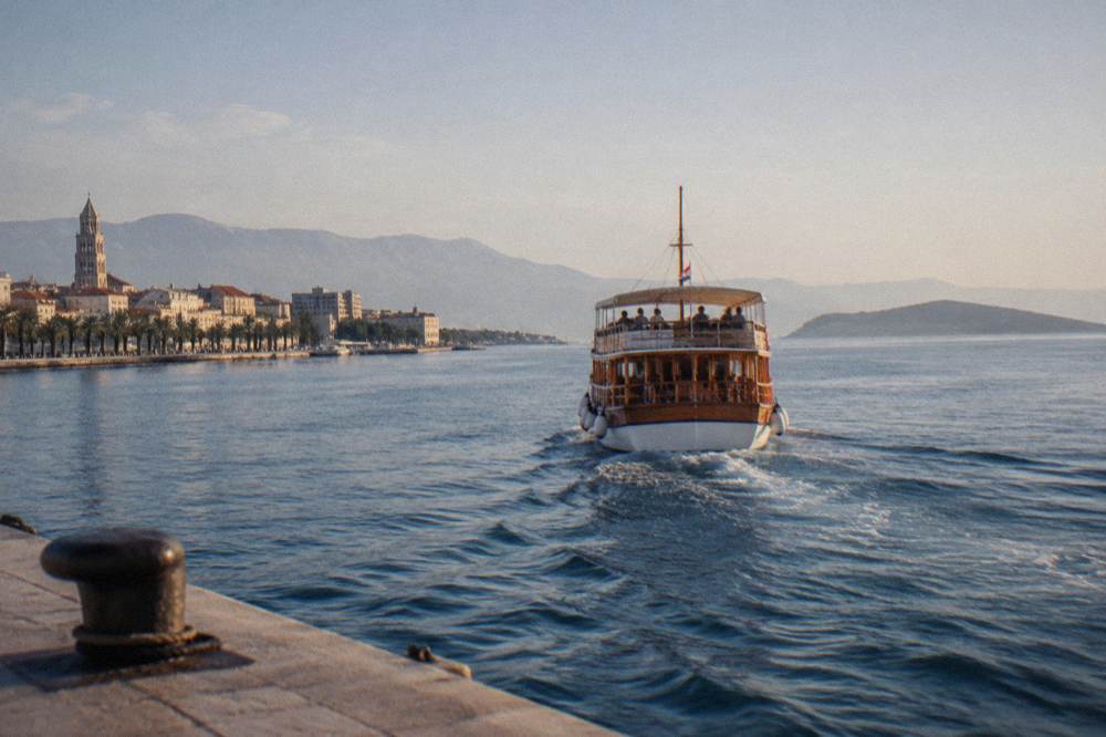 A wooden ferry departing Split harbour towards islands on a calm blue sea