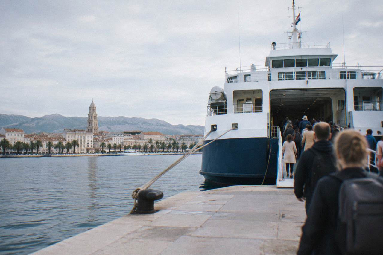 Ferry docked at the Split waterfront with passengers boarding in the morning sun