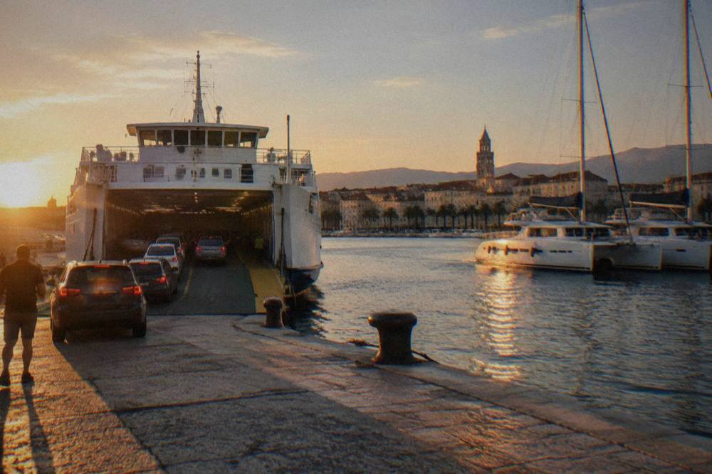Car ferry loading vehicles at a Split berth beside moored catamarans
