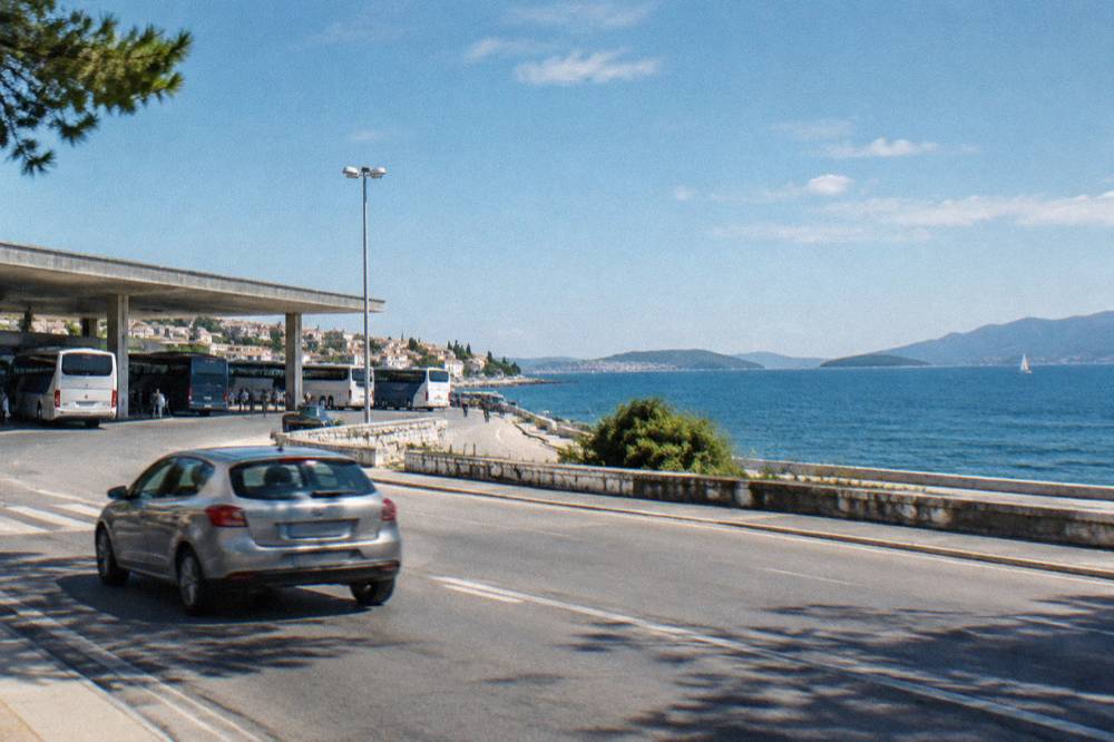 Car driving on a coastal road with the Adriatic Sea and islands in the distance