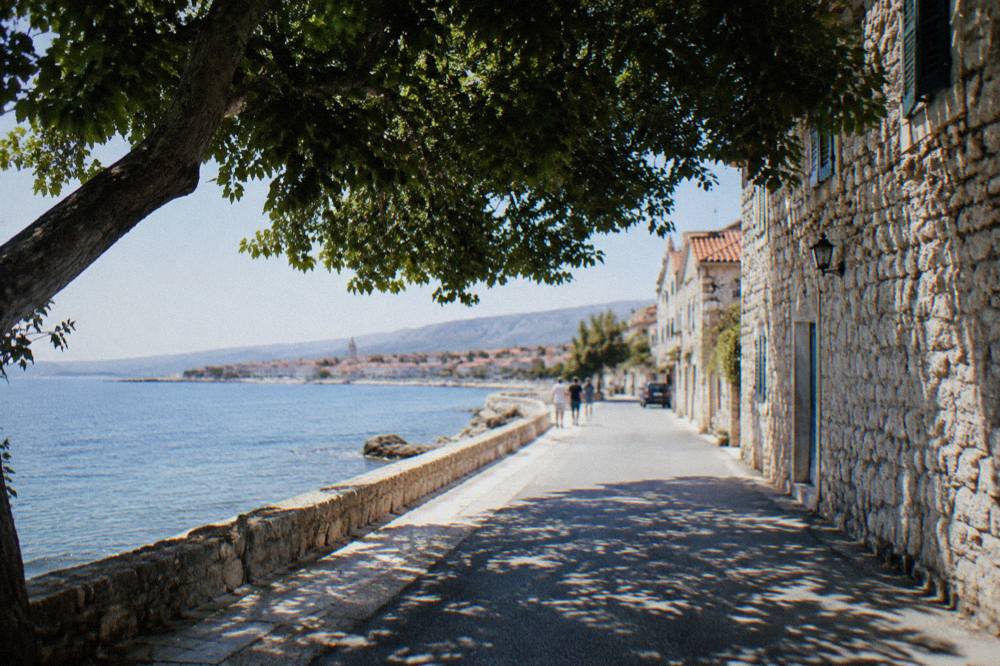 The coastal road between Kaštela and Split with the sea on one side and stone houses on the other