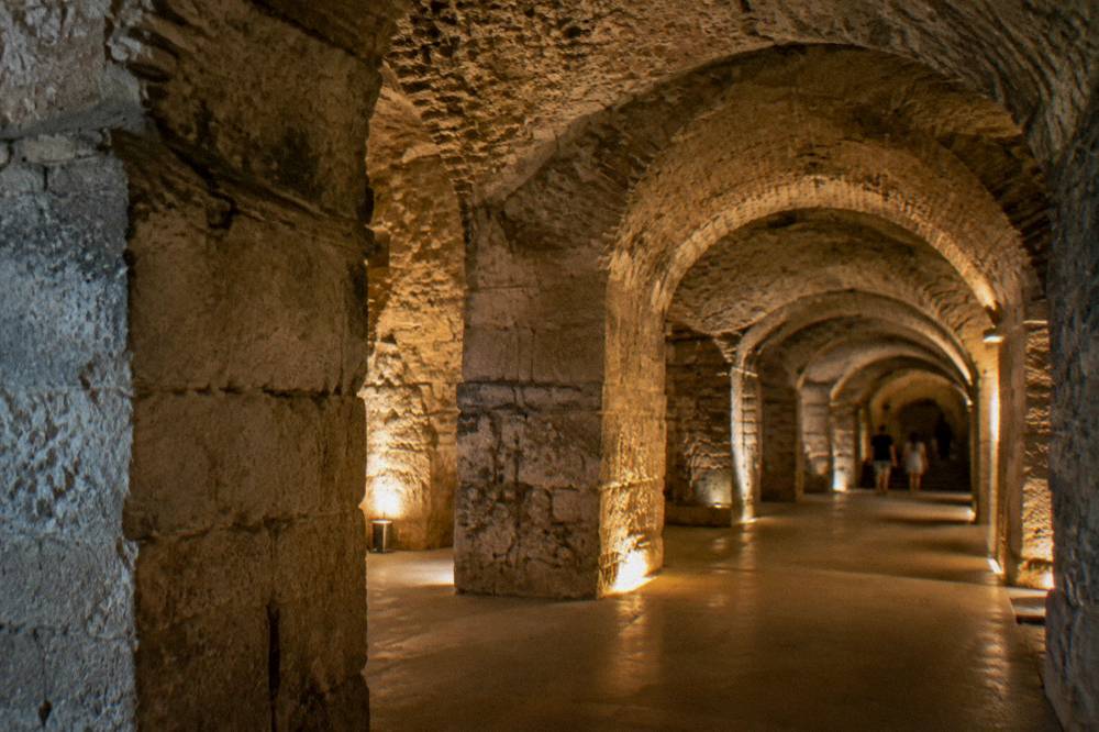 The vaulted stone cellars beneath Diocletian's Palace lit by warm lamps