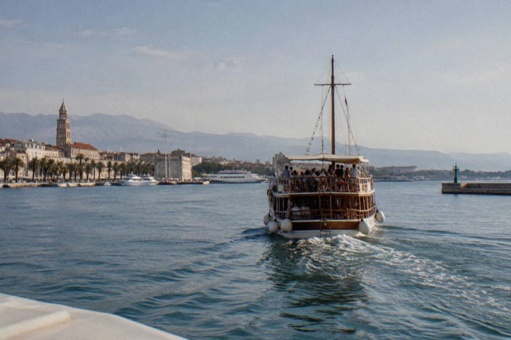 A wooden cruise boat packed with passengers leaving Split harbour in the late morning