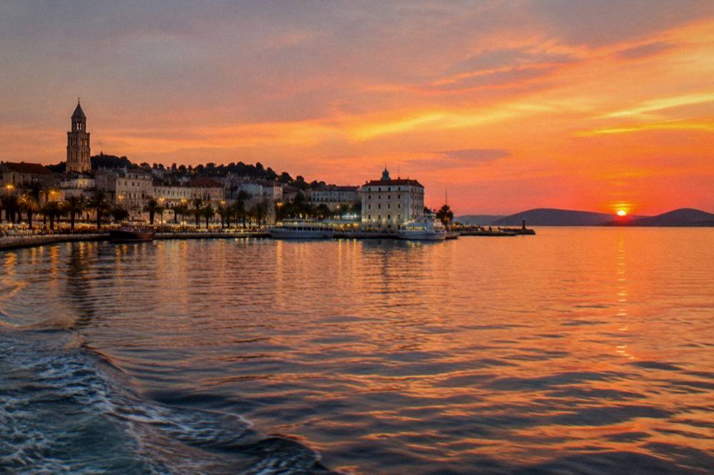 The lights of the Split waterfront and harbour at dusk seen from the sea