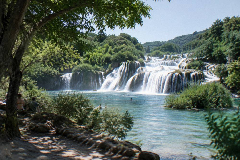 Wide waterfalls cascading over limestone steps at a national park in Dalmatia