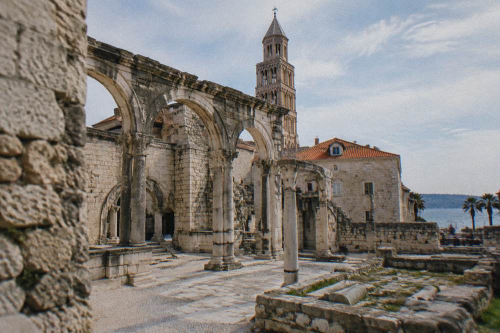 Stone Roman ruins under open sky on the edge of a Dalmatian town