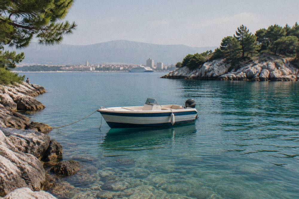 Small speedboat moored in a shallow turquoise cove between islands