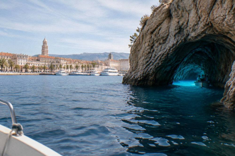 Bright blue light inside a sea cave reached by small boat