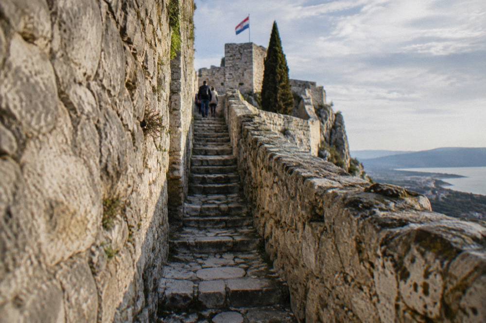 Narrow stone stairway inside Klis Fortress leading up between old walls