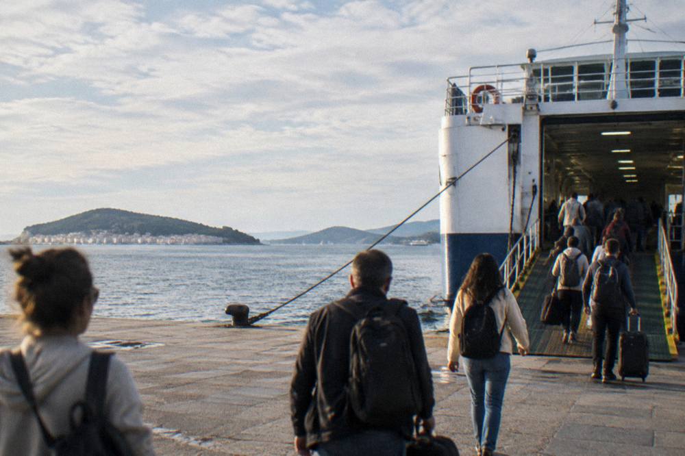 Passengers boarding a ferry at Split port with islands in the distance