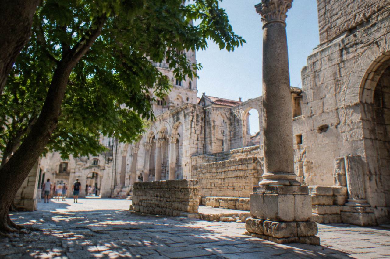 Ancient stone walls and columns of Diocletian's Palace in Split old town under warm daylight