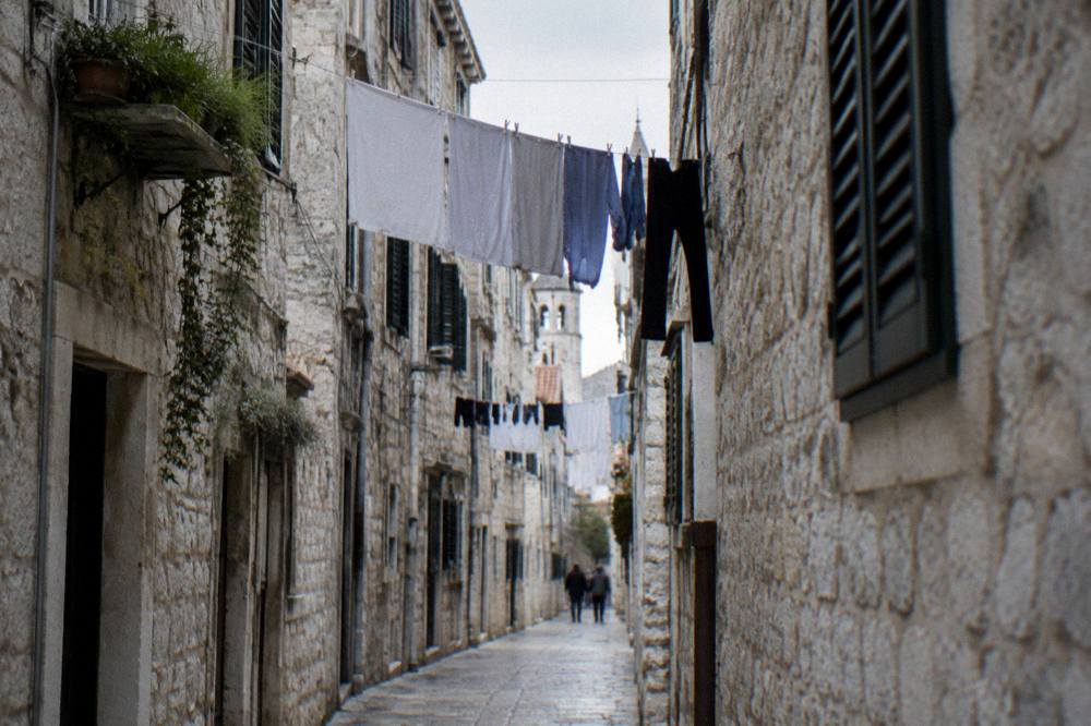 Narrow stone street in the old town with laundry hanging between historic houses