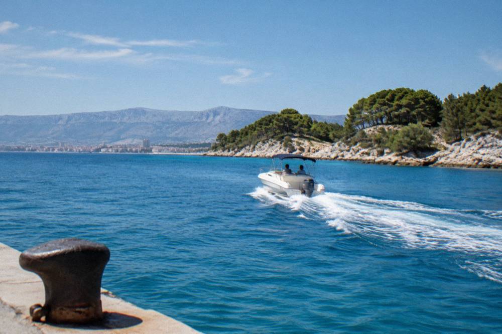 Private speedboat crossing clear Adriatic water toward island coves near Split