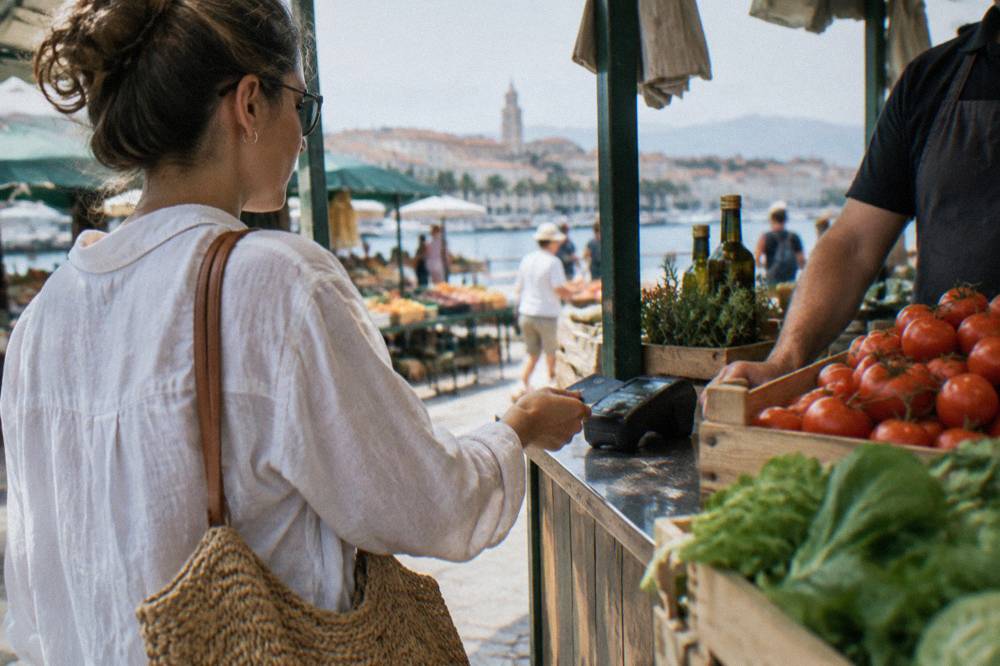 A customer paying with a contactless card at a small shop counter in Split