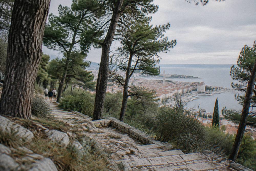 Stone steps and pine trees climbing Marjan hill above the rooftops of Split