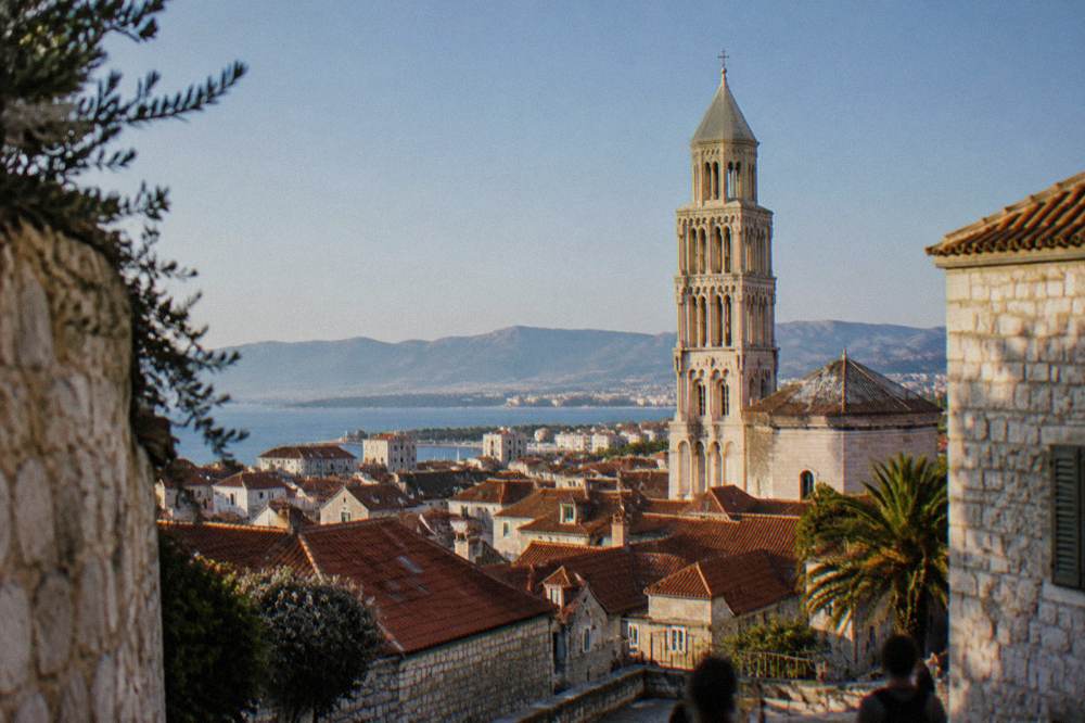 The stone bell tower and rooftops of the old quarter of Split seen from a distance