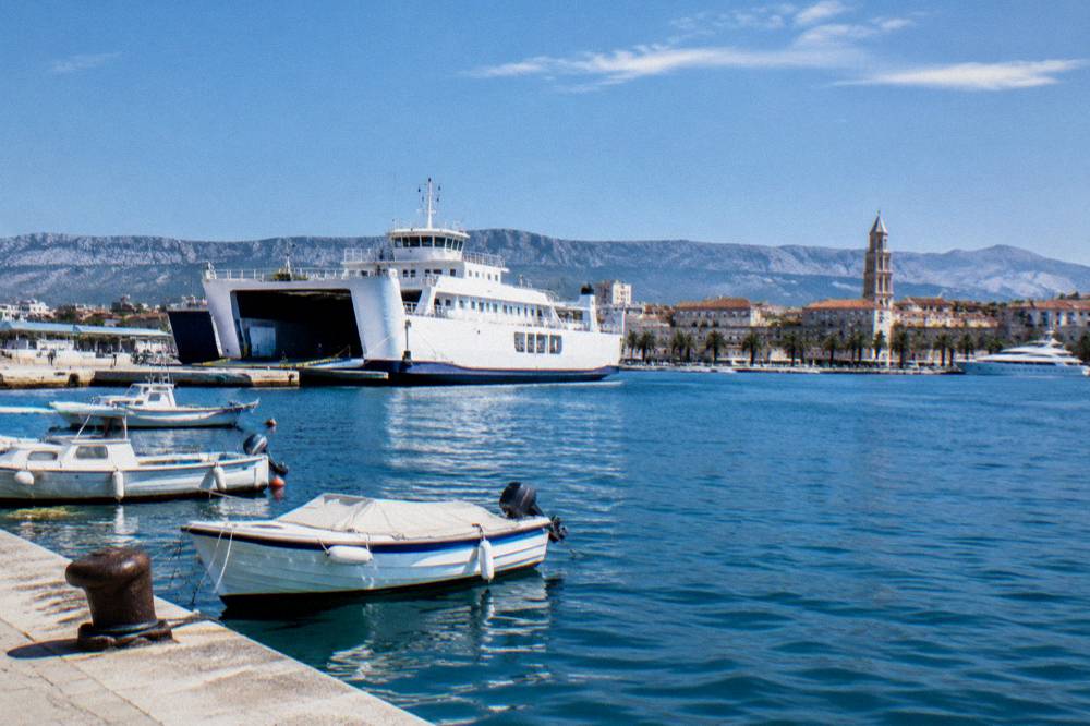 A car ferry and small boats moored along the seafront near the port of Split