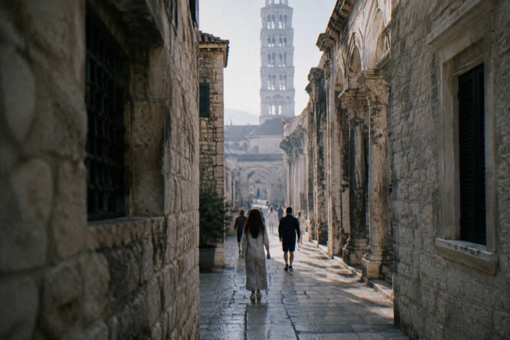 People walking through a narrow stone street inside Diocletian's Palace in Split
