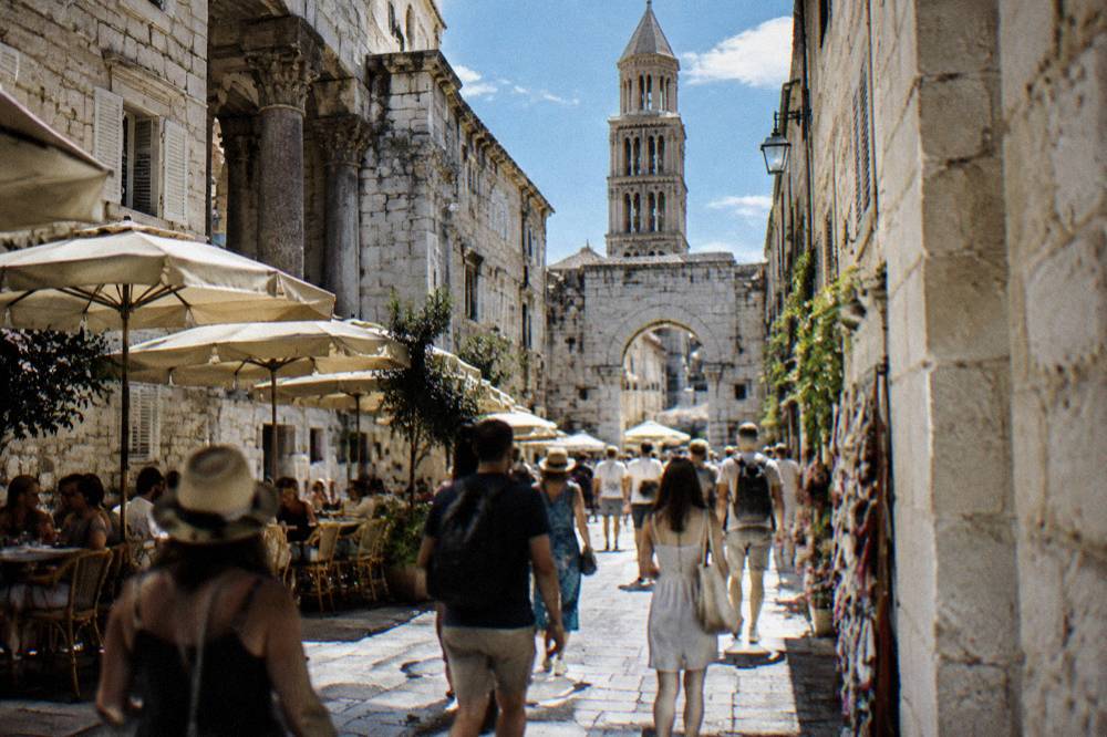 Crowded stone lane in the Split old town with cafes and shoppers in summer