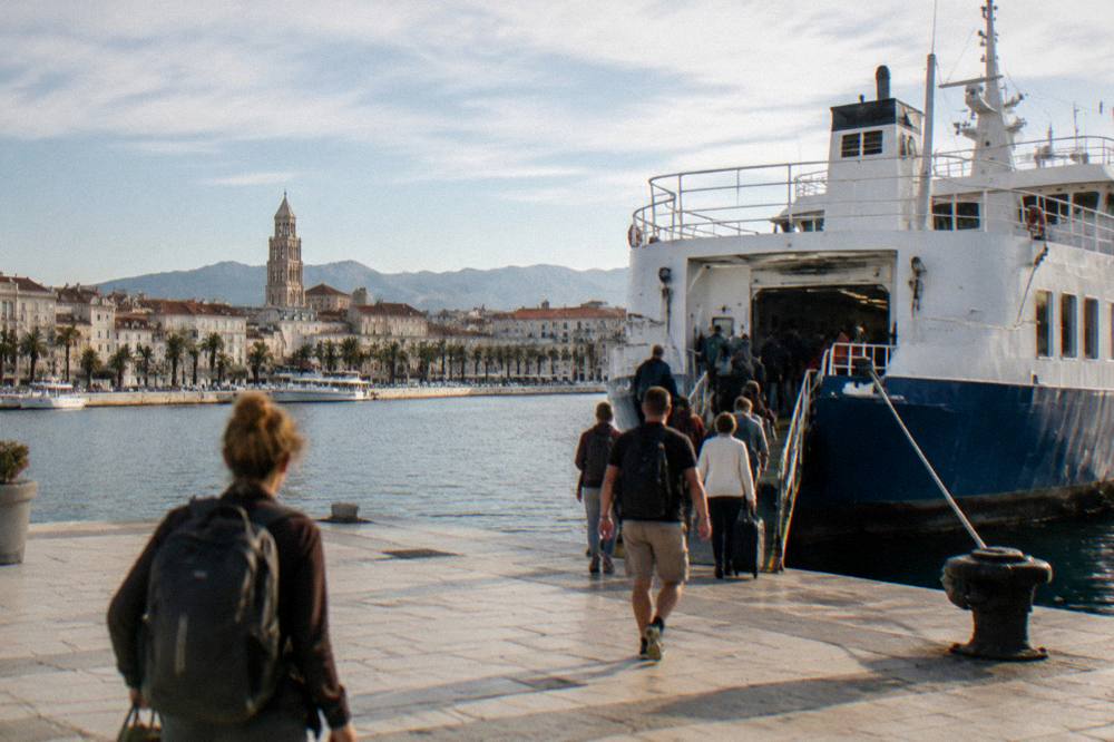 Ferry docked at the Split waterfront with passengers boarding on a clear day